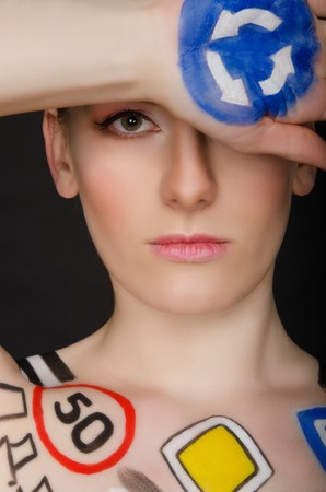 woman with traffic signs on her body, dark backgroundの写真素材