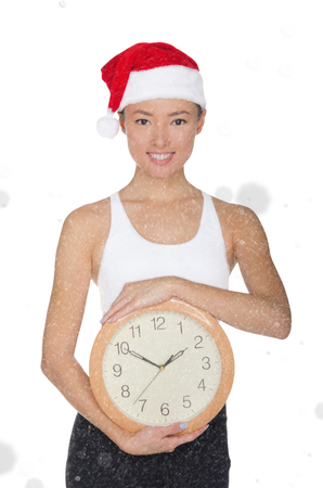 asian women in a Santa's hat with a clock isolated on whiteの写真素材