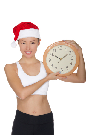 happy asian women in a Santa's hat with a clock isolated on whiteの写真素材