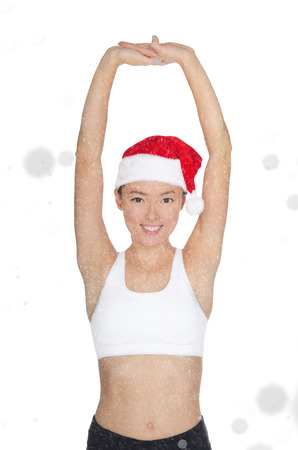 beautiful asian woman in Santa's hat engaged in fitness isolated on whiteの写真素材