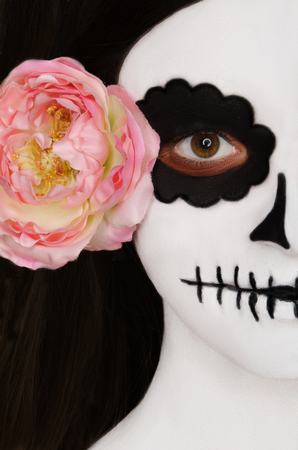 portrait with black and white face art on face on black backgroundの写真素材