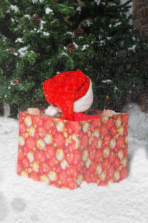 offended child in Santa suit waiting for the onset of Christmas sitting in a boxの写真素材