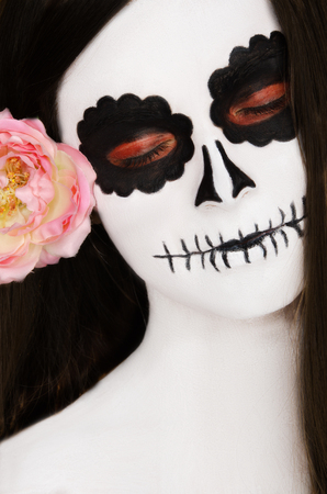 woman with black and white face art on her face on a black backgroundの写真素材