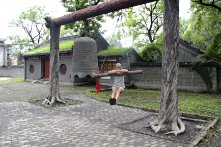 middle-aged man with gray hair on the background of ancient Chinese bellsの写真素材