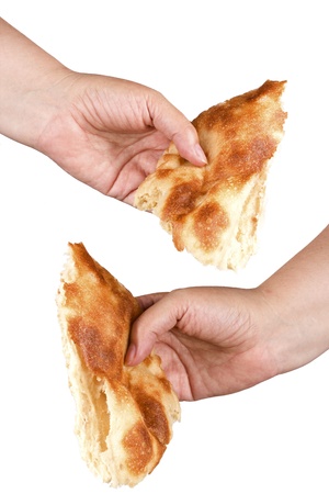 woman s hand holding a jagged piece of white bread on a white backgroundの写真素材
