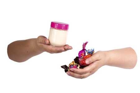 woman s hands holding a jar of yogurt and a few goodies on a white background の写真素材