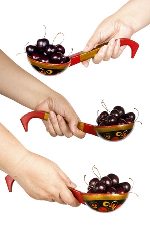 wooden spoon with cherries in handの写真素材