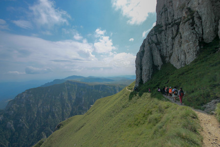 People walking on a mountain trail. Mountains with blue skyの写真素材