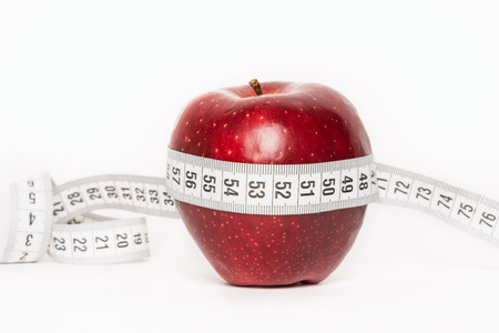 Healthy red apple with measuring tape isolated on white backgroundの写真素材