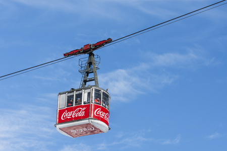 POIANA BRASOV, ROMANIA - JANUARY 24, 2016: Cable car cabin transports tourists from Poiana Brasov resort to Postavaru peak and ski slopes on sunny day with blue skyのeditorial素材