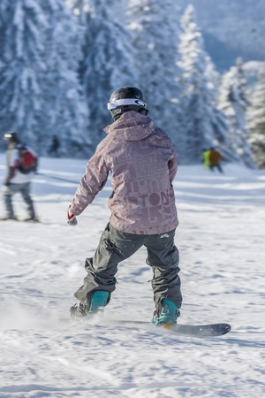 POIANA BRASOV, ROMANIA - JANUARY 24, 2016: Snowboarder sliding on ski slope during winter season in Poiana Brasov resort, Romaniaのeditorial素材