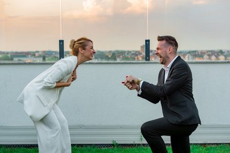 Man proposing his girlfriend on a rooftop of a building during sunset