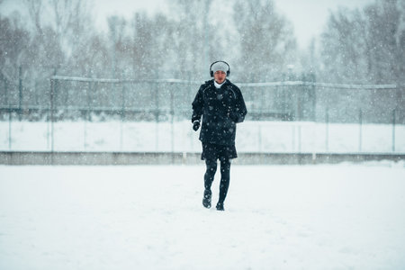 Handsome young man running and training on a cold winter dayの写真素材