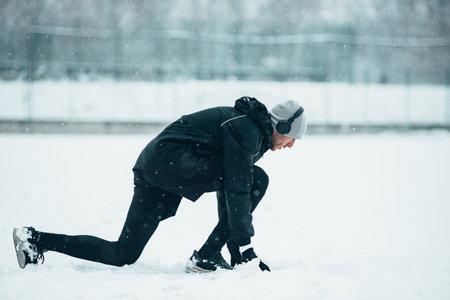 Handsome young man running and training on a cold winter dayの写真素材