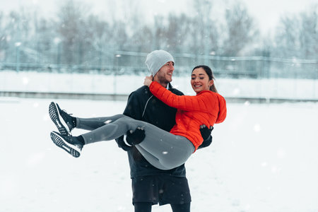 Young couple going for a run together during a snow on a cold winter dayの写真素材