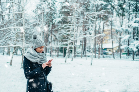 Shot of a beautiful young woman using a mobile phone on a snowy day outdoors