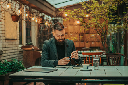 Young handsome businessman using   and a laptop while working in a coffee shopの写真素材
