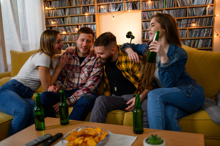 Group of friends on a house party hanging out together and drinking beer while having funの写真素材