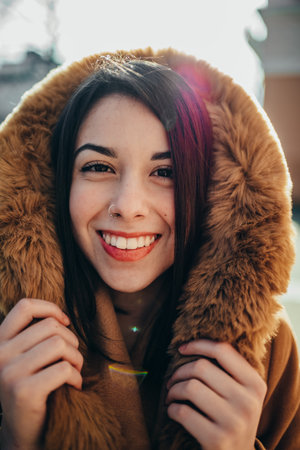 Portrait of a beautiful young woman standing outside in a winter coatの写真素材