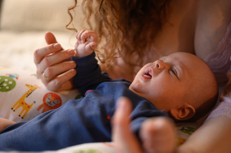 Mother bonding with her baby boy while helping him to learn how to sitの写真素材