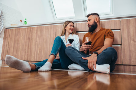 Shot of a happy couple enjoying some wine together at homeの写真素材