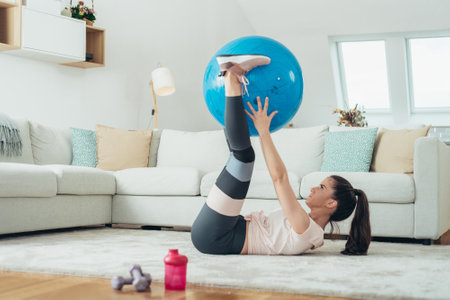 Shot of a beautiful young woman exercising at home aloneの写真素材