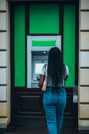 African american woman shot from behind using a atm machine