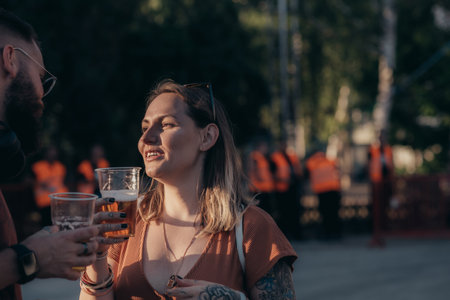 Romantic couple drinking beer and having fun at music festivalの写真素材