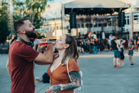 Beautiful couple drinking cocktails and having fun at music festivalの写真素材