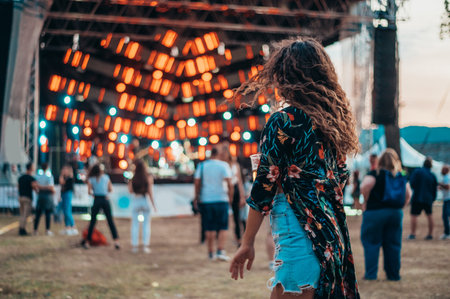 Beautiful woman drinking beer and having fun on a festival with her friendsの写真素材
