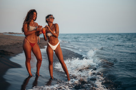 Attractive friends enjoying vacation together on the beach and drinking cocktailsの写真素材