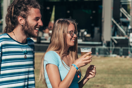 Teenage couple at summer music festival dancing in front of stage. Celebrating love. Romantic couple on a summer music festival.の写真素材