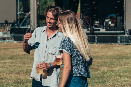 Teenage couple at summer music festival dancing in front of stage. Celebrating love. Romantic couple on a summer music festival.の写真素材