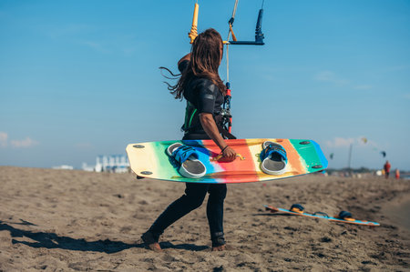 Woman holding a kite while still on the beach and preparing to go kitesurfing. Preparation before kiting.の写真素材
