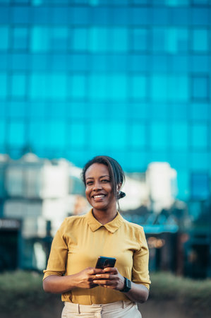 Beautiful young african american woman using a smartphone while out in the cityの写真素材