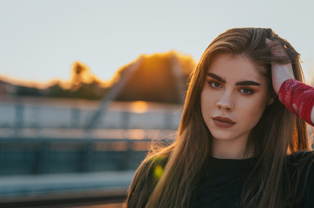 Portrait of a beautiful young woman outside on the sunsetの写真素材