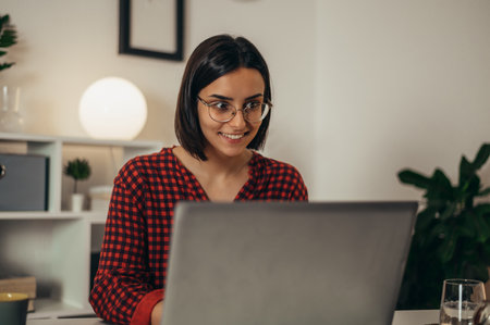 Beautiful woman using a laptop while managing her business and working remotely from homeの写真素材