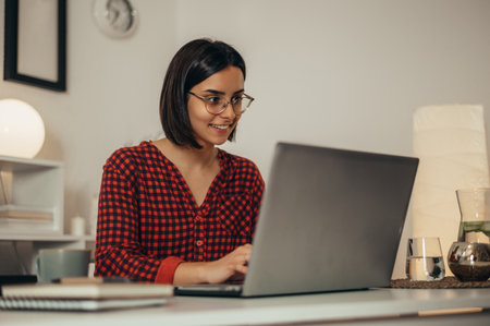 Beautiful woman using a laptop while managing her business and working remotely from homeの写真素材