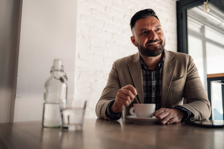 Handsome businessman drinking coffee in a cafeの写真素材