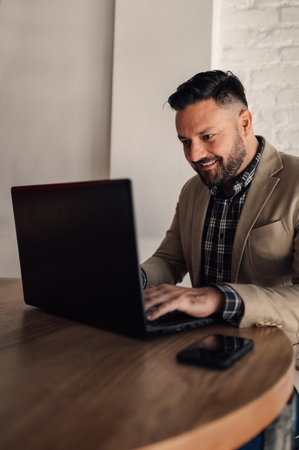 Handsome businessman working on his laptop in a cafeの写真素材