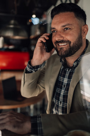 Handsome businessman using a smartphone in a cafeの写真素材