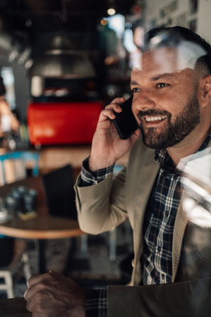 Handsome businessman using a smartphone in a cafeの写真素材