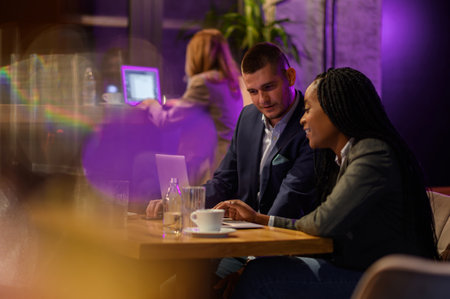Two business people having a meeting in a cafe while using a laptopの写真素材