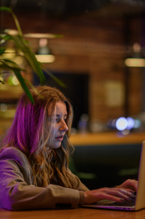 Young beautiful woman working on her laptop while sitting in a cafeの写真素材