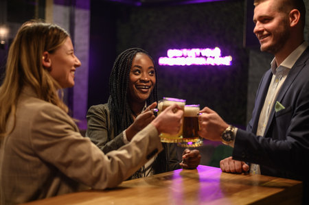 Cheerful colleagues drinking beer in the bar together after work