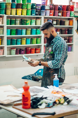 Male worker mixing colors for screen printing in a workshopの写真素材