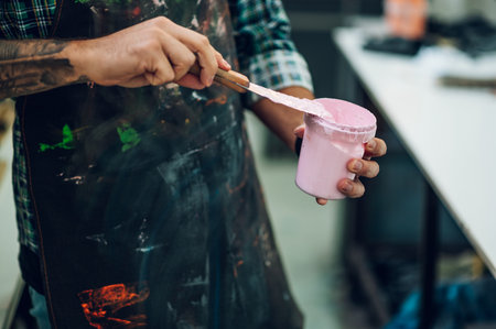 Male worker mixing colors for screen printing in a workshopの写真素材