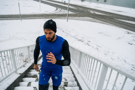 Man athlete running in winter cold and snow. Active and healthy life during winter. Winter exercise...
