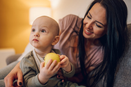 Adorable small baby boy and his mother enjoying moments of love and affection and learning to eat...