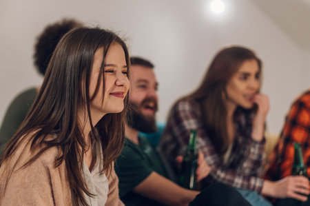 Friends sports fans watching winning football game on a TV at home. Friendship, leisure and people concept.の写真素材